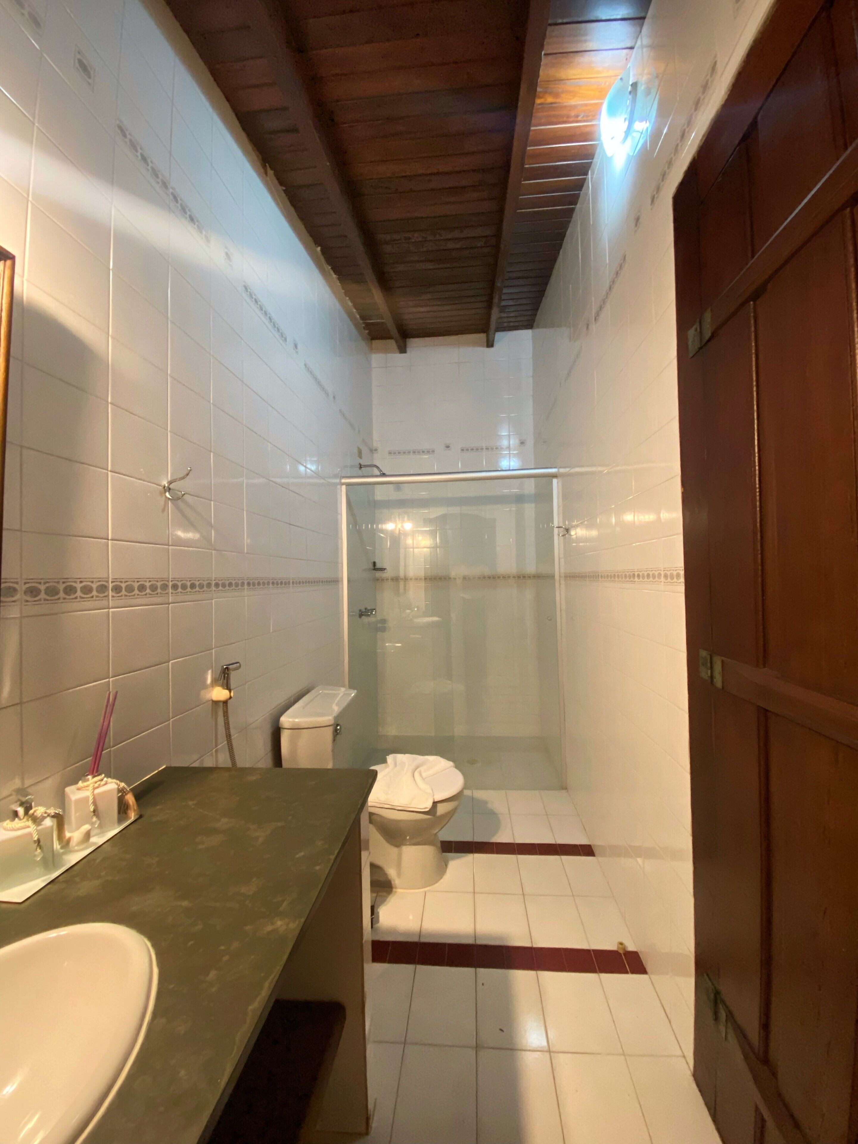 Ein Badezimmer mit Dusche, Toilette und Waschbecken.