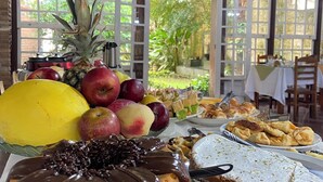 Ein Buffett mit verschiedenen Früchten, Gebäck und einer mit Schokolade überzogenen Torte.