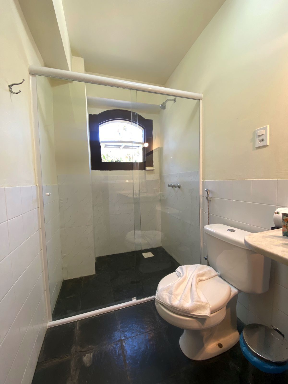 Een badkamer met een douchecabine, een toilet en een wastafel.