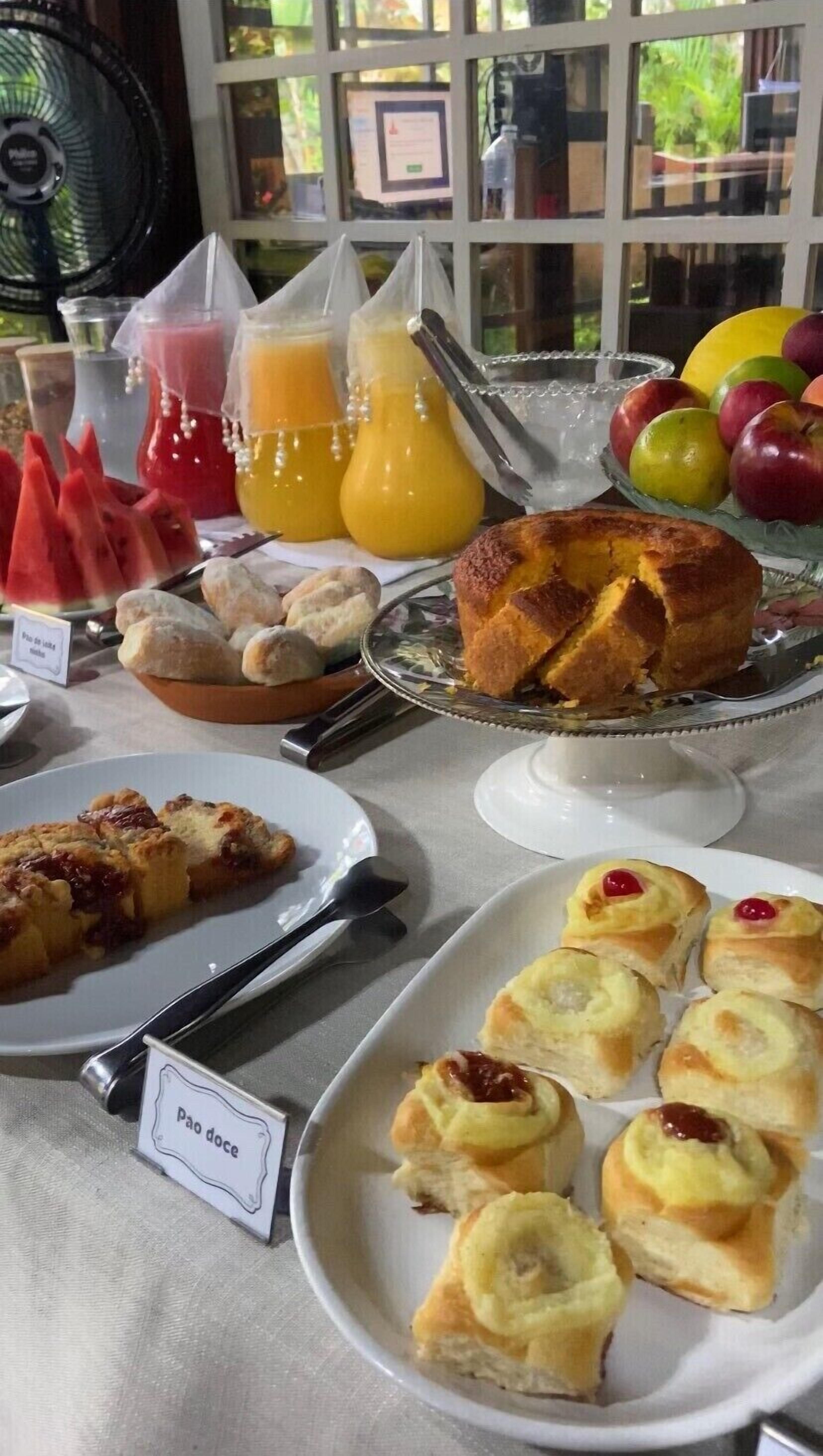 A breakfast buffet with various pastries, fruits, and juices.