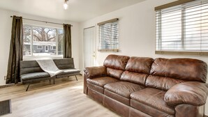 A living room with a brown leather sofa, a grey sofa, and a window with blinds. - Covered Patio, Gas Grill & Yard: Sheridan Home! (Sheridan)