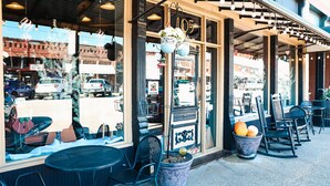 A storefront with large windows, outdoor seating, and decorative elements like hanging lights and potted plants. - New Year’s Retreat. Cozy Modern Farmhouse! Close to historic downtown Wylie! (Wylie)