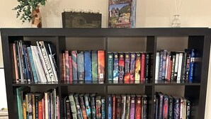 Une bibliothèque remplie de divers ouvrages, un vase avec des plantes vertes et un livre intitulé « Si les granges pouvaient parler ».