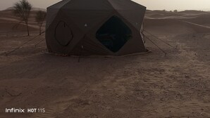A geodesic dome tent in a desert setting.