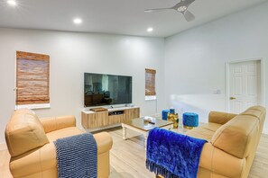 A modern living room with a sofa set, a coffee table, and a television on a wooden cabinet. - Port St Lucie Canal-front Home w/ Heated Pool! (Port Saint Lucie)