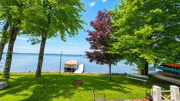Une terrasse au bord du lac, dotée d’un espace salon couvert, d’un petit quai pour bateaux et d’une pelouse.