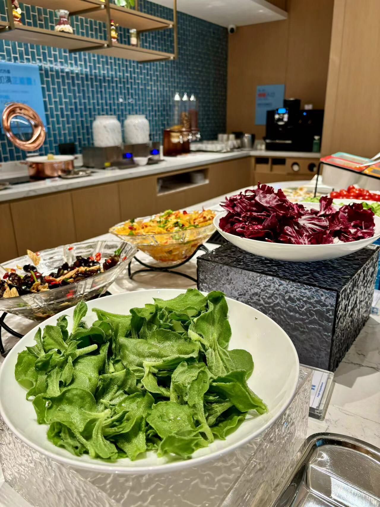A buffet setup with various dishes including salads and vegetables.