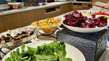 A buffet setup with various dishes including salads and vegetables.