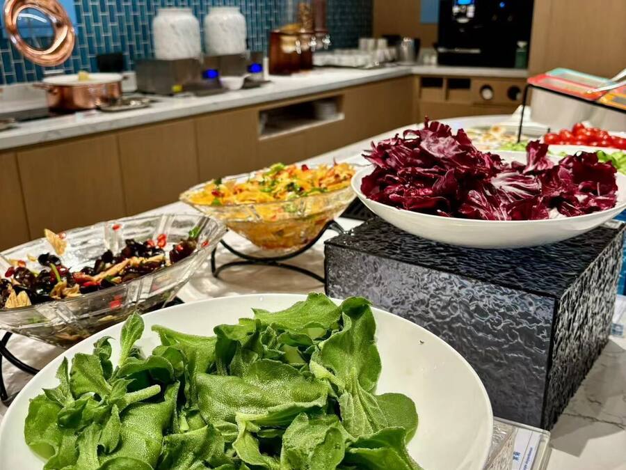A buffet setup with various dishes including salads and vegetables.