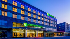 A Holiday Inn Express hotel with a modern facade, large windows, and a well-lit entrance. - Holiday Inn Express Beijing Conference Center by IHG (Beijing)