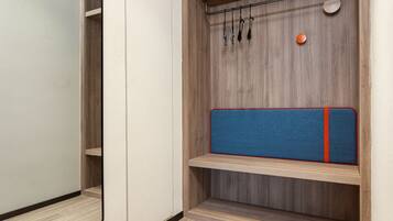 A wooden wardrobe with a mirror, a hanging rack, and a blue padded shelf.