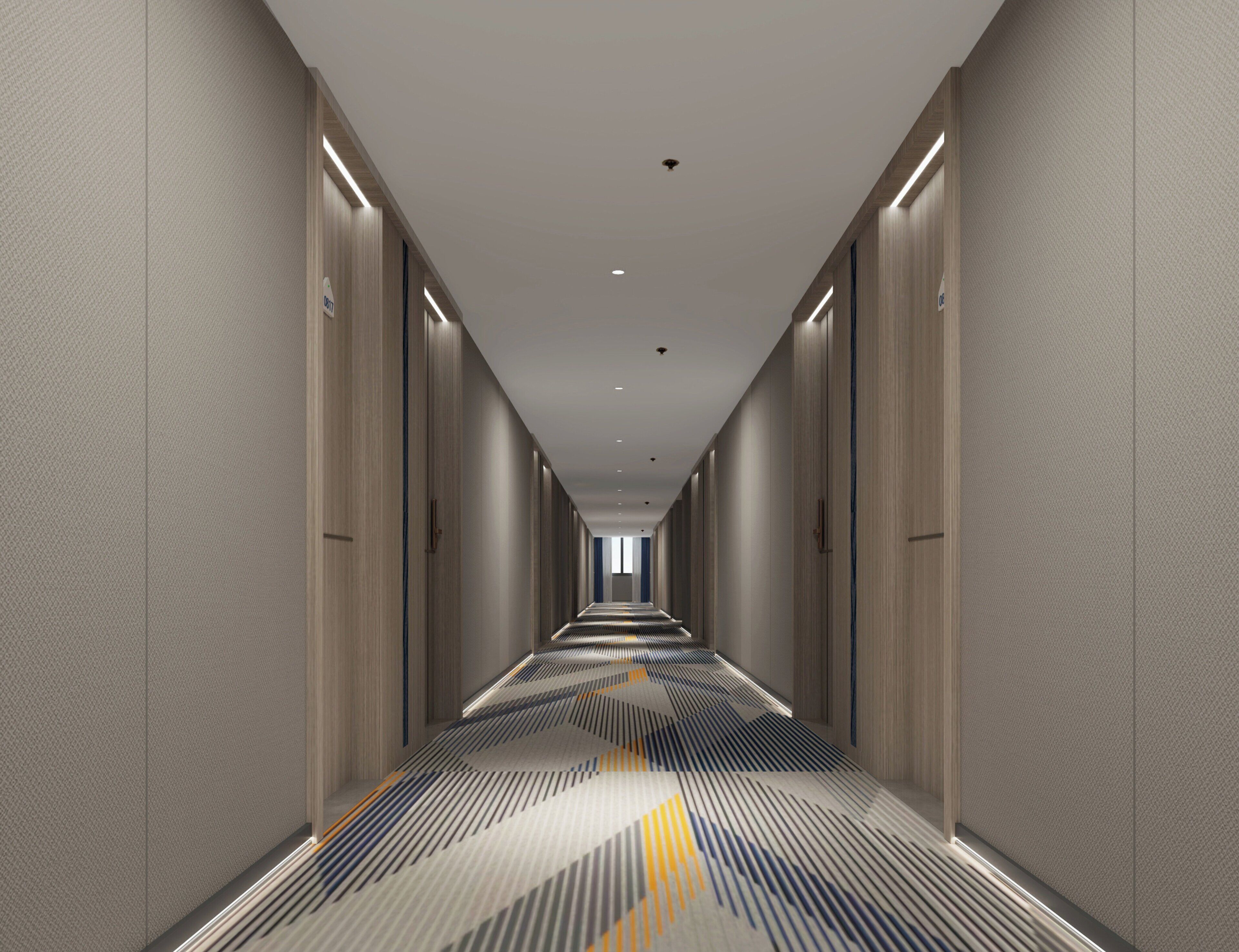 A long, narrow hotel corridor with a patterned carpet, light-colored walls, and doors on both sides.