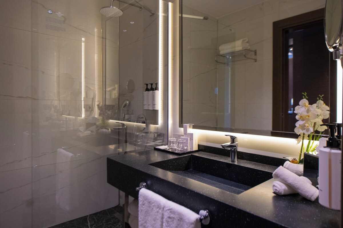 Luxe beddengoed, een kluis op de kamer, een bureau, een laptopwerkplek