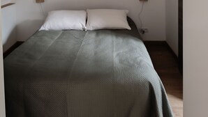 A bedroom with a bed, two wall-mounted lamps, and a world map artwork on the wall. - Rez de Villa au Calme T2 + Terrasse Privative sur la Colline (Vidauban)