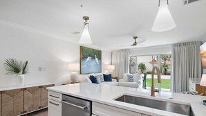 Een moderne keuken met een centraal eiland, een ingebouwde vaatwasser en een groot raam met uitzicht op de omgeving.