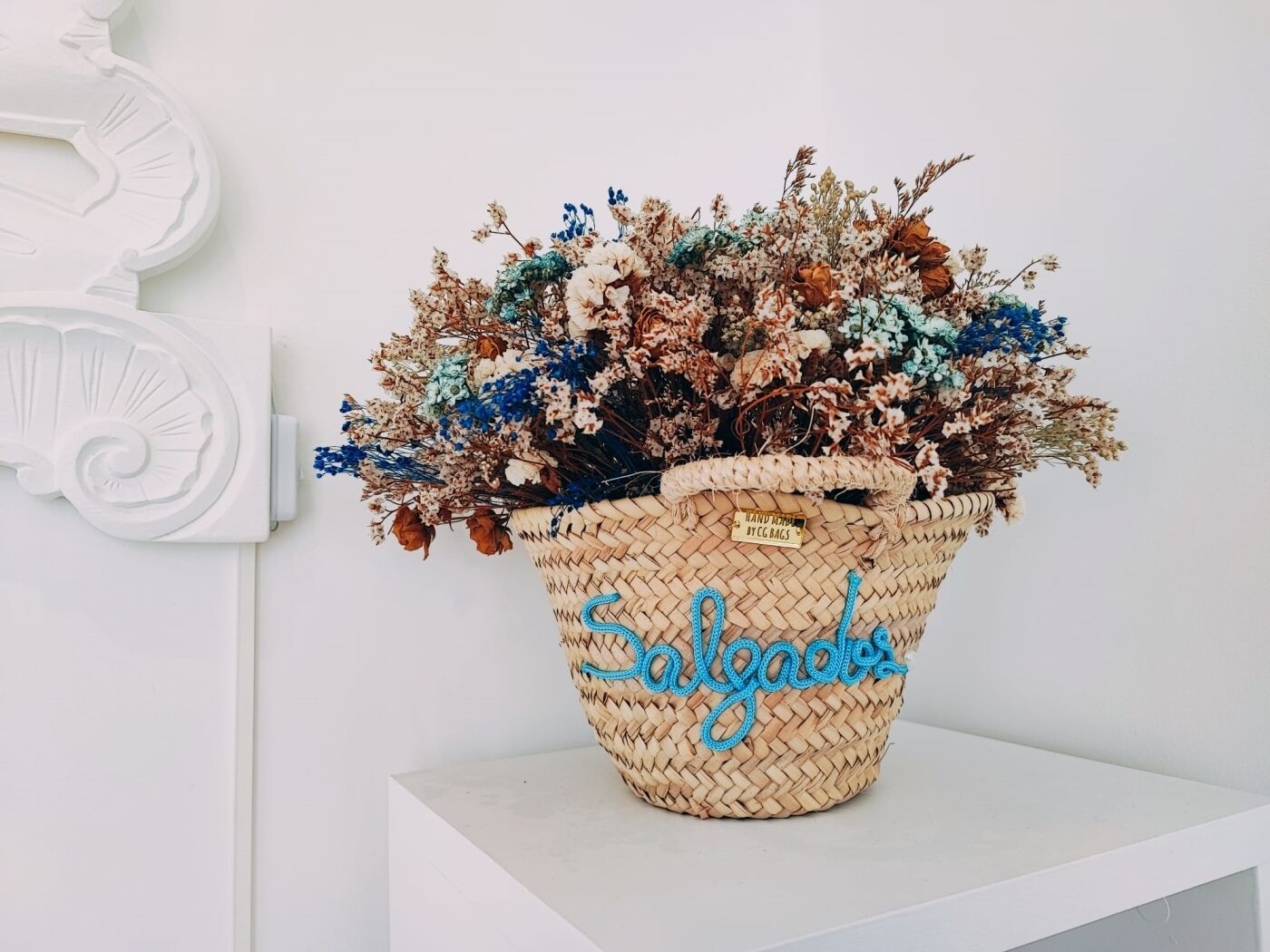 A woven basket with a label reading "Hand Made By CG Bags" and the word "Salvage" on it.