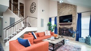 Un salon avec un canapé, une table basse et une cheminée.