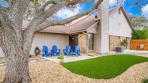 Une maison avec un patio couvert, un arbre et une pelouse.