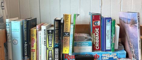 Una estantería con varios libros y juegos de mesa.