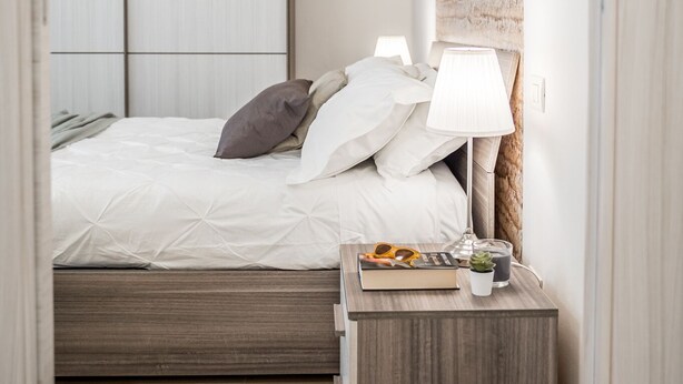 Ein Schlafzimmer mit Bett, Nachttisch und Kleiderschrank.
