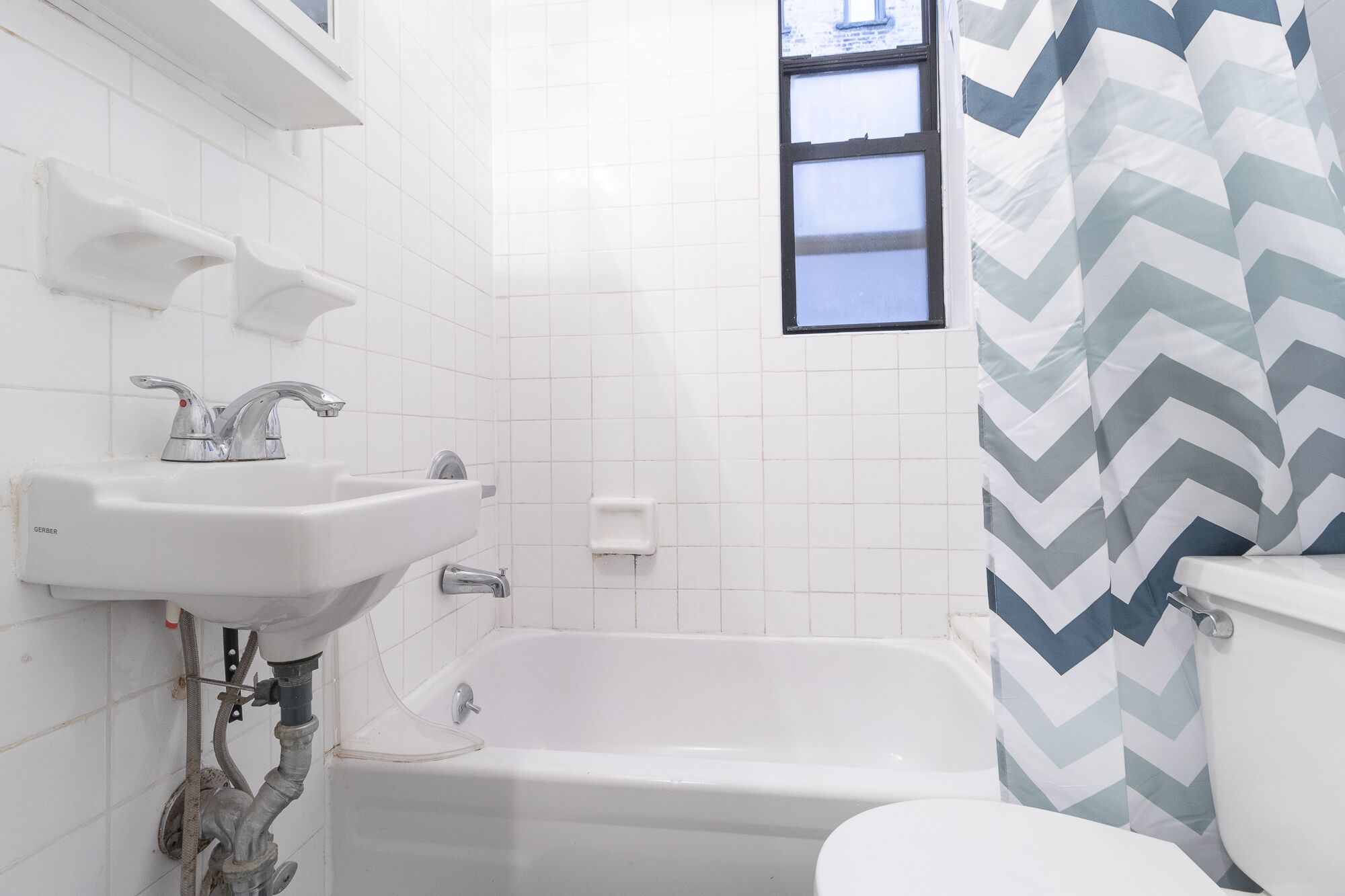 Une salle de bain avec un lavabo blanc, une baignoire et des toilettes.