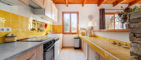 A kitchen with wooden cabinets, a tiled backsplash, and a stone accent wall.