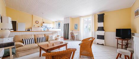 A spacious living area with a sofa, chairs, a coffee table, and a television.