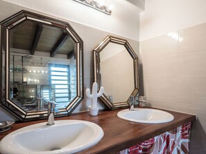 A bathroom with two sinks, a large mirror, and a shower area. - Villa Ekinos is ideally located within walking distance of the beaches. (Le Moule)