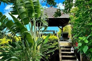 Escape to a serene tropical oasis with a shaded area and lush surroundings.