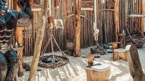 Ein Zimmer mit rustikaler Holzverkleidung, einem Holzschemel und einem kleinen Tisch.