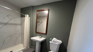 A bathroom with a shower, sink, and toilet. - La Familia Stay Inn (Quincy)