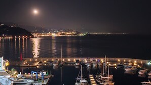 A marina at night with boats docked, a calm sea, and a cityscape in the background. - Apartment 'Icon Marina B' with Sea View, Wi-Fi and Air Conditioning (La Herradura)