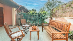 A patio with wooden furniture, a table, and a bench.