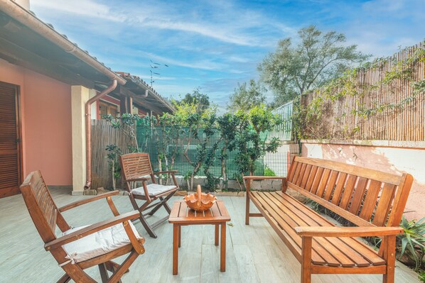 A patio with wooden furniture, a table, and a bench.