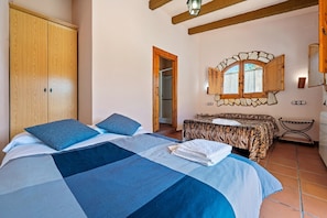 Ein Schlafzimmer mit einem großen Bett, einem Kleiderschrank, einem Spiegel und einem kleinen Tisch.