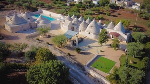 Un village traditionnel avec des maisons en pierre, une piscine et un petit terrain de football.