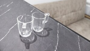 Två klara glas på ett mörkt marmorbord.