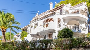 A white building with balconies, a staircase, and a palm tree. - Studio Apartment 'Sillero Dos' with Shared Pool, Wi-Fi and Air Conditioning (Moraira)