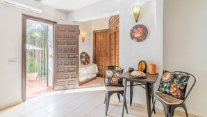 A dining area with a table, chairs, and a decorative wall. - Studio Apartment 'Sillero Dos' with Shared Pool, Wi-Fi and Air Conditioning (Moraira)