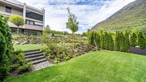 Een modern gebouw met een tuin vol planten en een kleine boom.