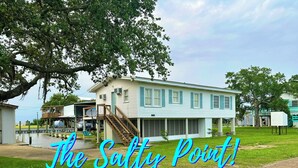 A two-story house with a porch and a staircase leading to the second floor. - The Salty Point....a waterfront fishing cottage with kayaks, ping pong and more! (Franklin)