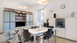 Une cuisine moderne avec une table à manger, des chaises, une horloge et des placards intégrés.