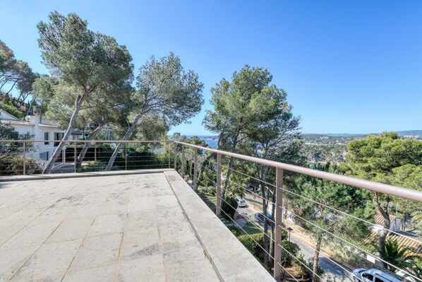 A balcony with a metal railing overlooking a residential area with trees and a clear sky. - Holiday Home 'La Brisa' with Sea View, Wi-Fi and Air Conditioning (Llafranc)