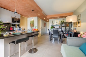 Une cuisine moderne dotée d’un coin bar, d’un espace repas et d’un salon avec un canapé et une lampe.