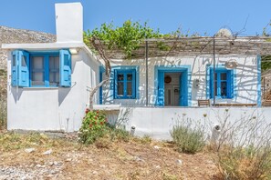 Un edificio blanco con contraventanas azules y un pequeño porche.