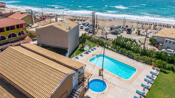 A hotel with a swimming pool, beach view, and a mountainous backdrop. - Apartment 'Mires House  11' with Sea View, Wi-Fi and Air Conditioning (Corfu)