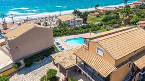 Un hôtel en bord de mer doté d’une piscine, offrant une vue sur la plage et présentant une architecture méditerranéenne.