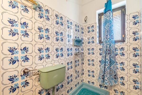 A bathroom with a toilet, sink, shower, and patterned tiles. - Studio Apartment 'Mires House Front 1' with Sea View, Wi-Fi and Air Conditioning (Corfu)
