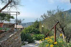 A stone staircase with a metal railing, surrounded by greenery and yellow flowers. - Apartment 'Ca' Dû Massunin' with Sea View, Wi-Fi and Air Conditioning (Recco)