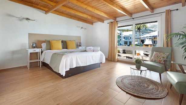 A bedroom with a bed, bedside table, and a view of the outside. - Holiday Home 'Casa Evarista' with Sea View, Private Terrace and Wi-Fi (Icod de los Vinos)